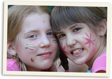 Painting faces at a summer camp-out Happy girls with painted faces